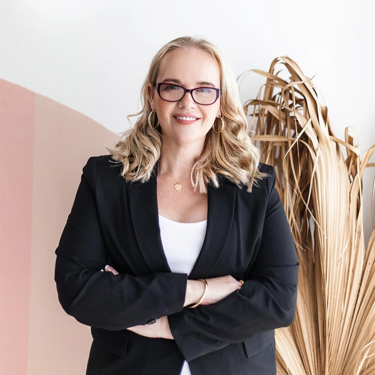 A picture of Natasha Sutton wearing a black jacket with her arms folded.